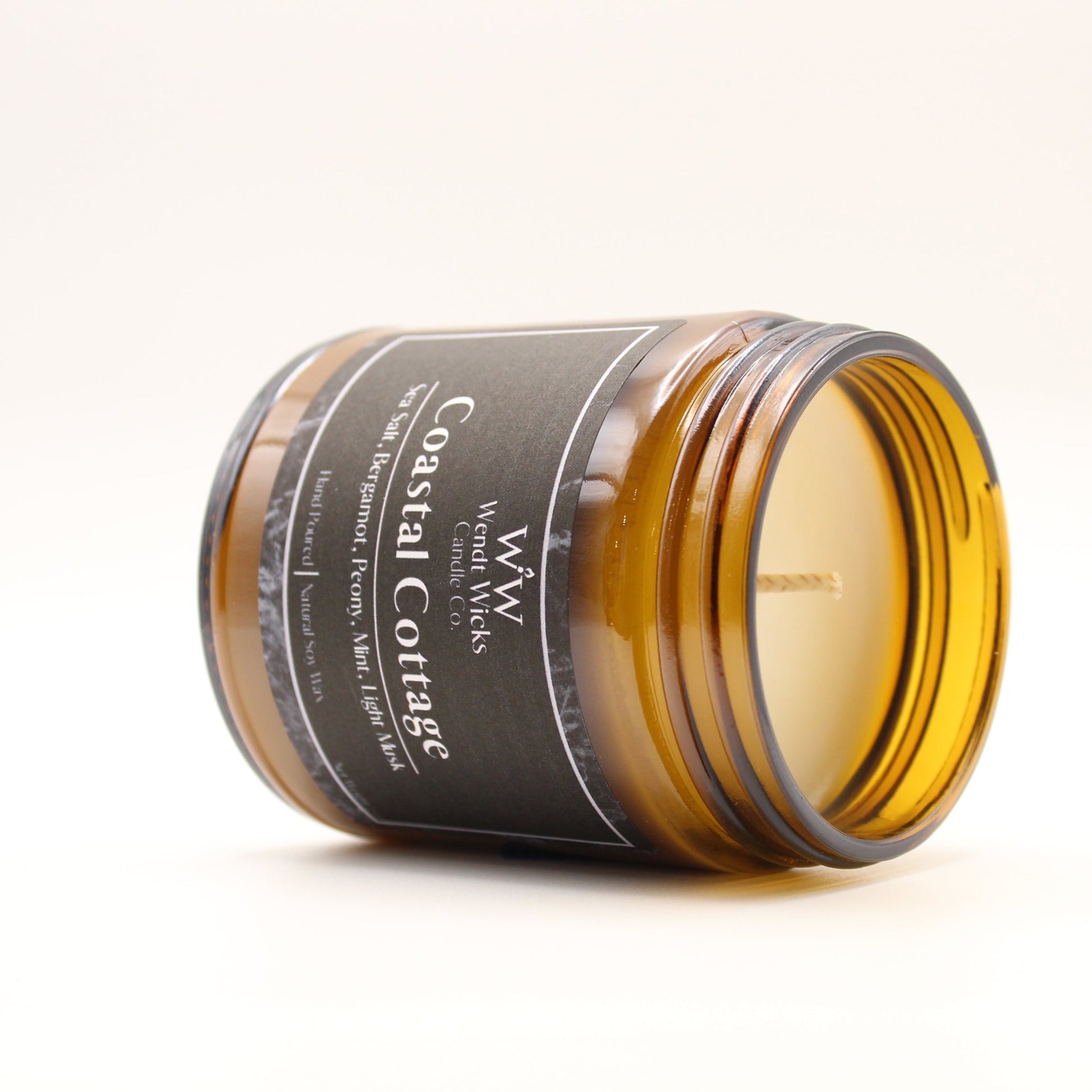 Jar of candle with 'Coastal Cottage' label on a white background