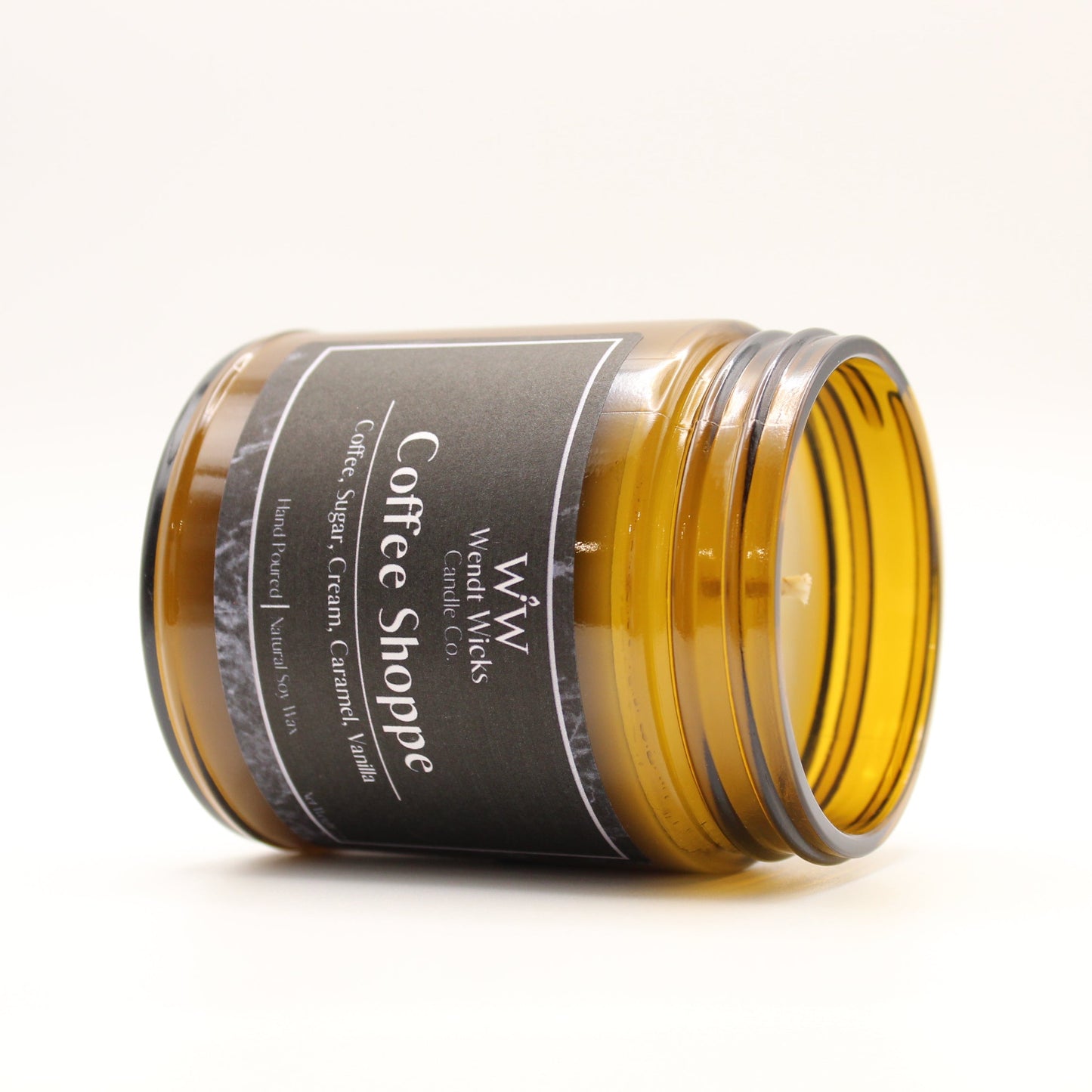 Jar of coffee shoppe candle with visible label on a white background