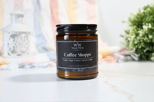 Wendt Wicks Coffee Shoppe candle on a white surface with a blurred background