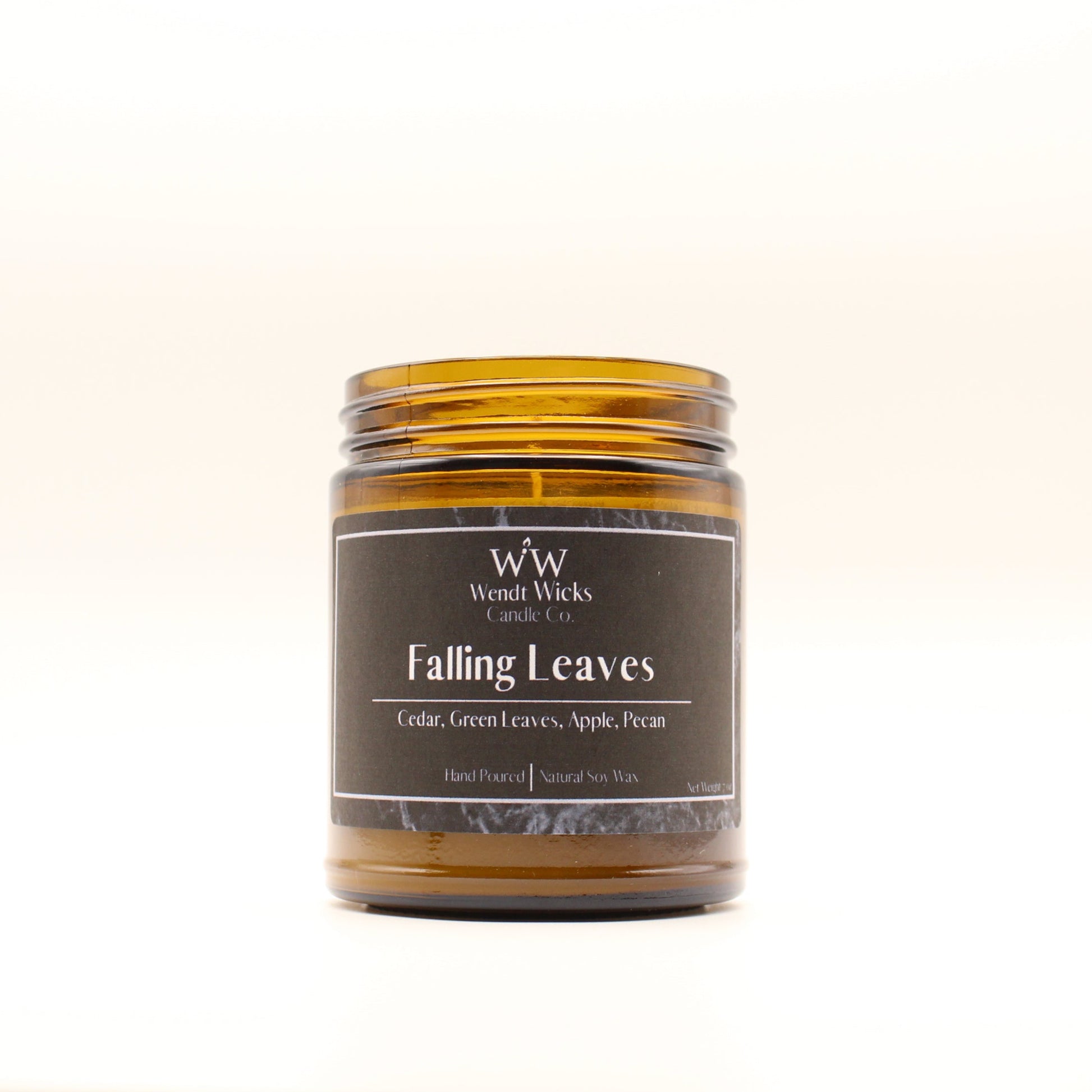 Wendt Wicks amber glass jar candle. Candle labeled 'Falling Leaves'  on a white background