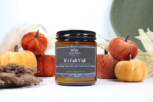 Wendt Wicks amber glass jar candle with black lid. Candle labeled 'It's Fall Y'all' with pumpkins and decorative Autumn elements on a white background