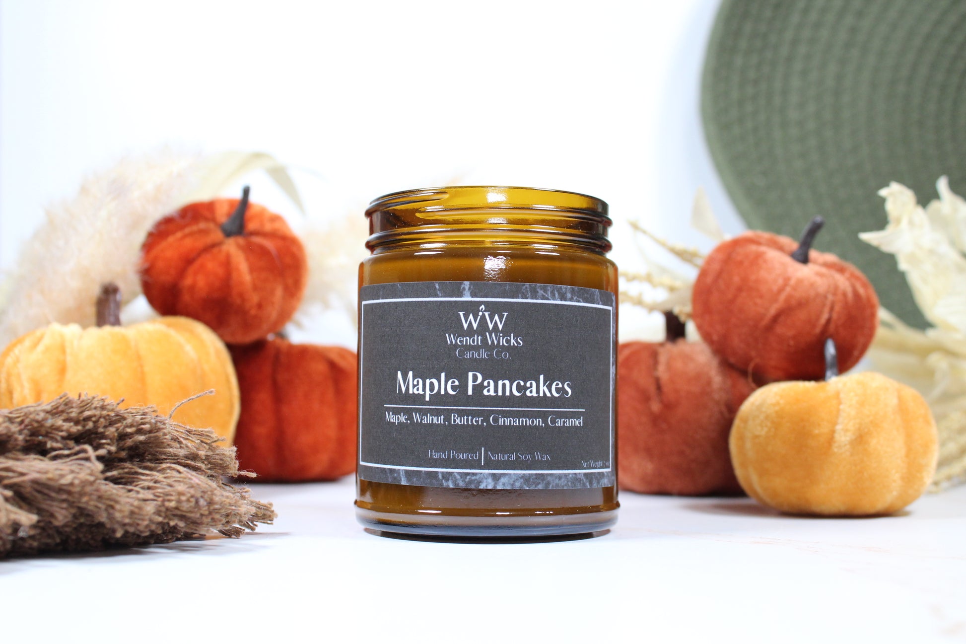 Wendt Wicks amber glass jar candle. Candle labeled 'Maple Pancakes' with pumpkins and decorative Autumn elements on a white background