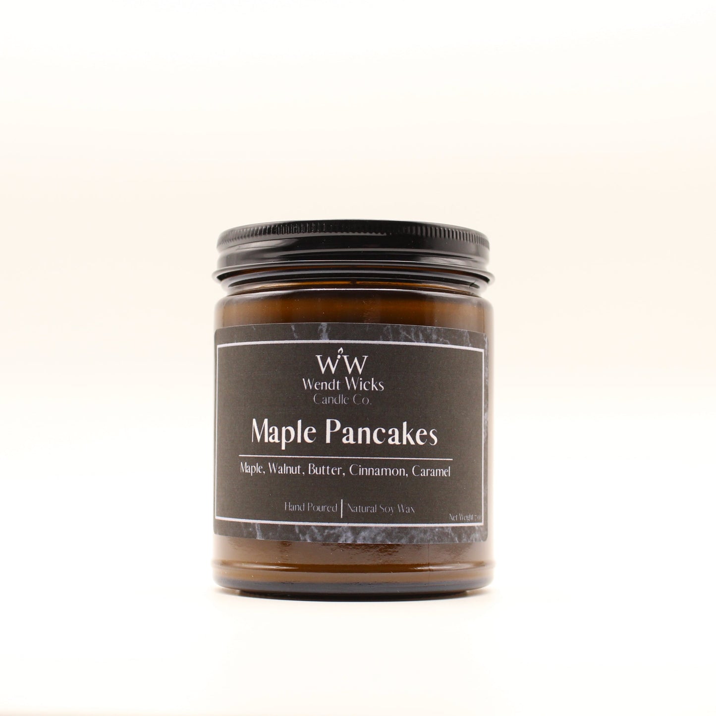 Wendt Wicks amber glass jar candle with black lid. Candle labeled 'Maple Pancakes' on a white background
