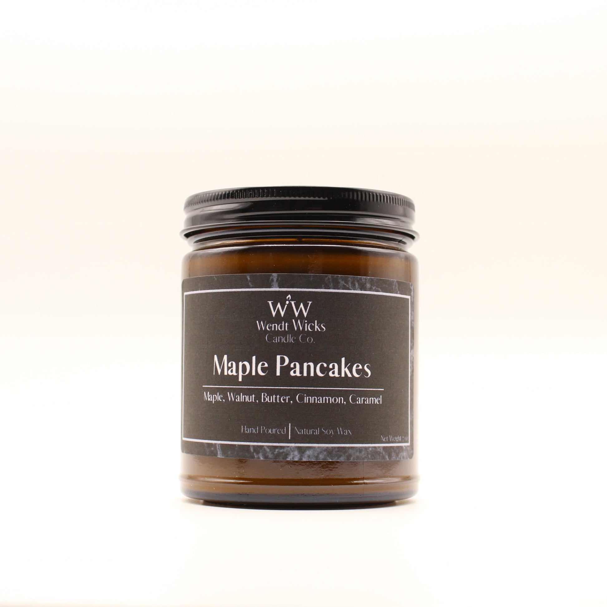 Wendt Wicks amber glass jar candle with black lid. Candle labeled 'Maple Pancakes' on a white background