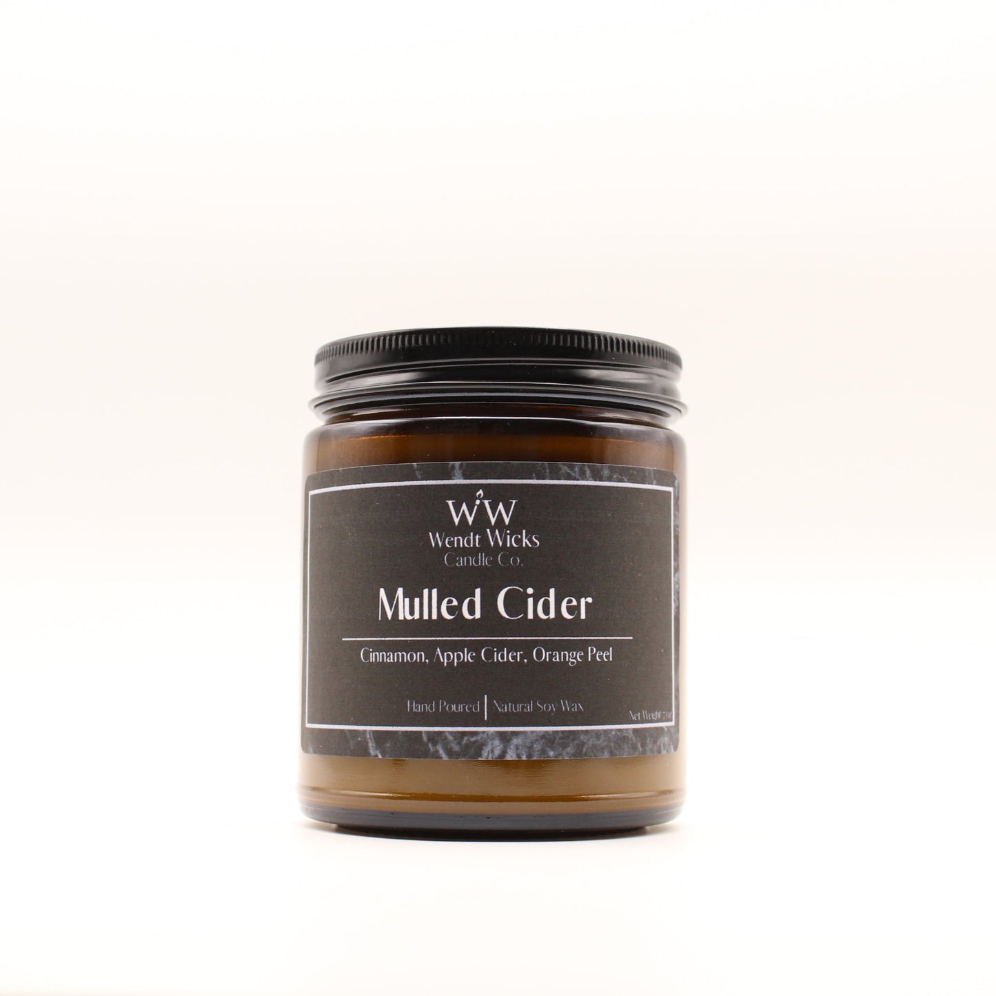 Wendt Wicks amber glass jar candle with black lid. Candle labeled 'Mulled Cider' on a white background
