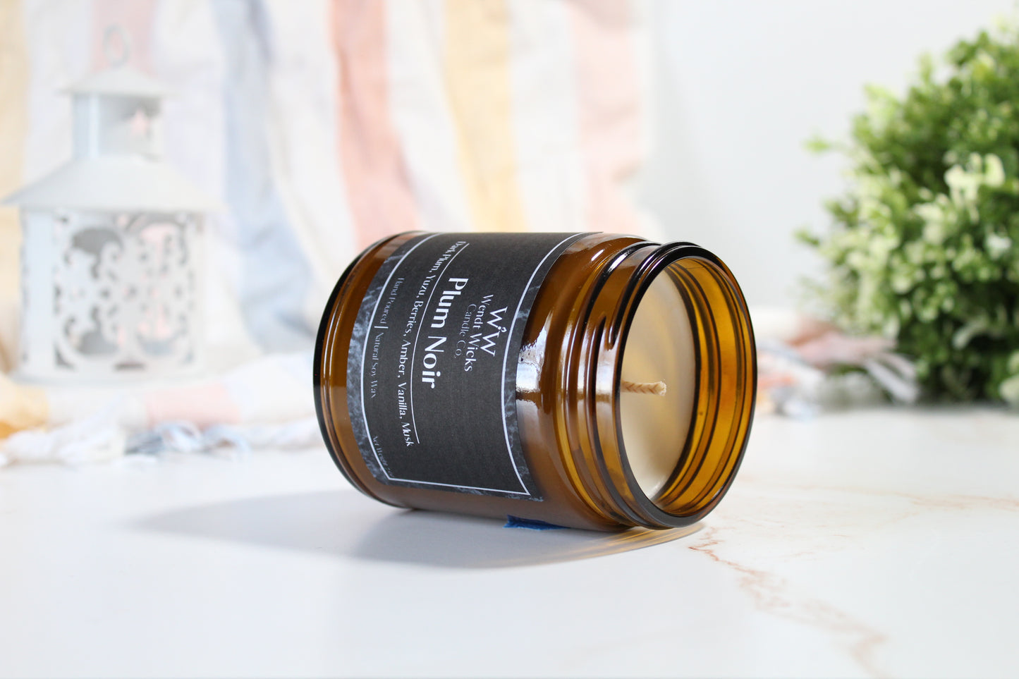 Brown candle jar with a label on a light surface