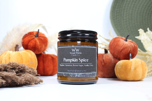 Wendt Wicks amber glass jar candle with black lid. Candle labeled 'Pumpkin Spice' with pumpkins and decorative Autumn elements on a white background